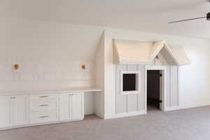 Bonus room with light colored carpet and lofted ceiling