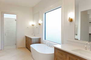 Bathroom with a wealth of natural light, vanity, and shower with separate bathtub