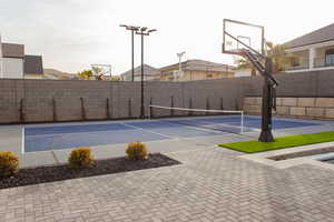 View of tennis court featuring basketball hoop