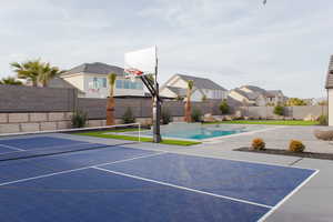 View of basketball court featuring a fenced in pool