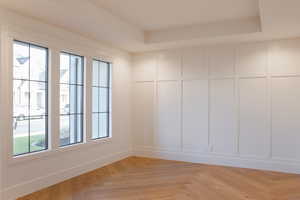 Unfurnished room with light parquet floors and a raised ceiling