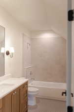 Full bathroom with tile patterned floors, tiled shower / bath combo, toilet, and vanity