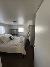 Bedroom featuring dark carpet and a textured ceiling