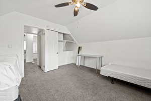 Unfurnished bedroom featuring carpet flooring, ceiling fan, a closet, and vaulted ceiling