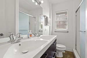 Bathroom with tile patterned flooring, vanity, an enclosed shower, and toilet