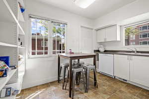 Kitchen featuring dishwasher, white cabinets, and sink