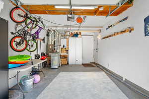 Garage featuring tankless water heater and a garage door opener