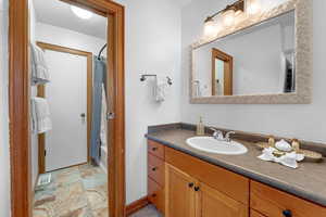 Bathroom featuring vanity and shower / bathtub combination with curtain