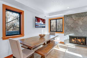 Dining room with a fireplace, a textured ceiling, and light hardwood / wood-style flooring