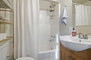 Full bathroom featuring shower / tub combo, vanity, and toilet