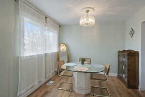 Dining space with a notable chandelier and light hardwood / wood-style flooring