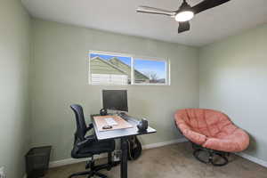 Office area with light colored carpet and ceiling fan