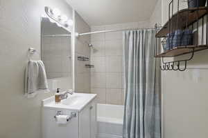 Bathroom with vanity and shower / tub combo with curtain