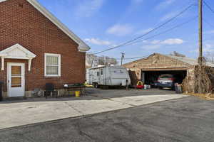 View of side of home with a garage and an outbuilding