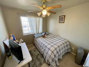 Carpeted bedroom featuring ceiling fan