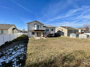 Rear view of house featuring a lawn, a patio area, and a deck