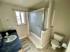 Bathroom with a shower, vanity, and toilet