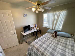 Carpeted bedroom featuring ceiling fan