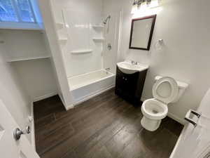 Full bathroom with hardwood / wood-style flooring, vanity, toilet, and bathing tub / shower combination