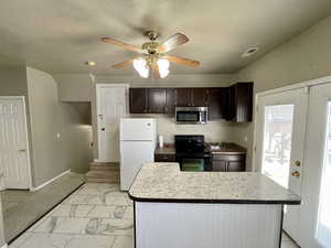 Kitchen featuring ceiling fan, a center island, black range with electric cooktop, white fridge, and a textured ceiling