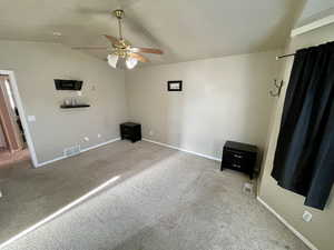 Unfurnished bedroom featuring ceiling fan, carpet, and lofted ceiling