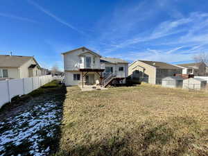 Rear view of house featuring a lawn, a patio area, and a deck