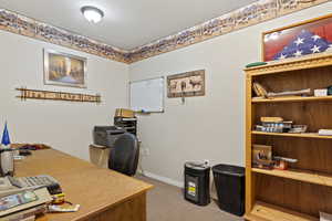 Office area with a textured ceiling and carpet floors