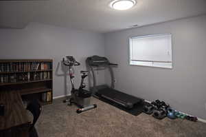 Exercise area with carpet floors and a textured ceiling