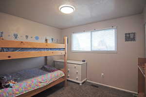 Carpeted bedroom featuring a textured ceiling