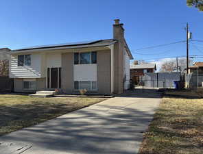 View of front of home with solar panels and a front lawn