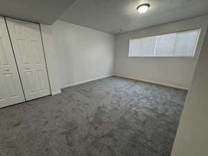 Unfurnished bedroom featuring dark carpet and a closet