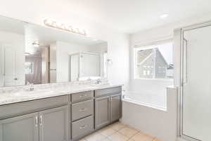 Bathroom with tile patterned flooring, vanity, and independent shower and bath