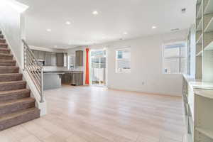 Unfurnished living room with light hardwood / wood-style floors and sink