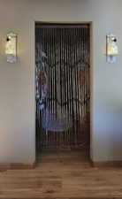 Interior details of primary walk in closet with baseboards and wood finished floors