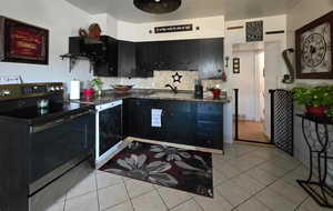 Kitchen with dishwasher, sink, electric stove, decorative backsplash, and light tile patterned flooring