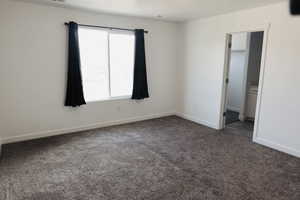 Carpeted spare room featuring plenty of natural light, master bedroom.