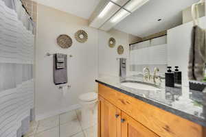 Bathroom with tile patterned flooring, vanity, and toilet