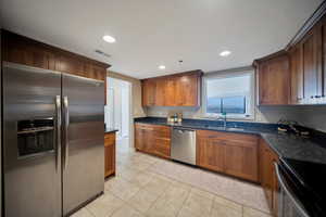 Kitchen featuring stainless steel appliances, dark granite countertops