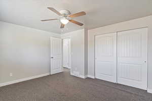 Largest bedroom with a textured ceiling, carpet, a closet, and ceiling fan