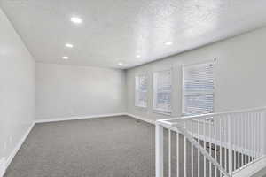 front family room featuring a textured ceiling and carpet floors