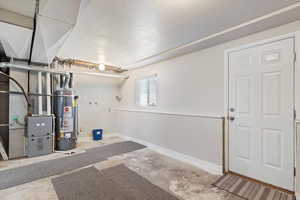 Interior space with a textured ceiling, heating unit, and gas water heater, room to finish a bedroom