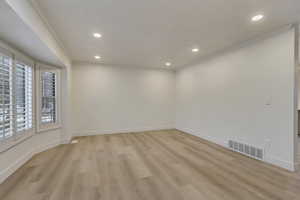 Unfurnished room featuring light hardwood / wood-style floors and crown molding