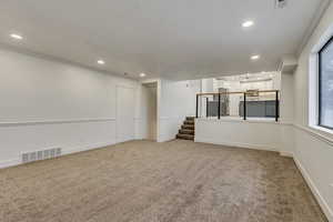 Spare room featuring crown molding and carpet