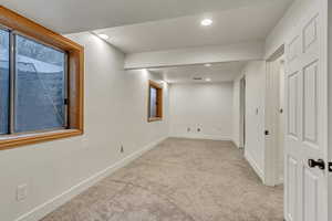 Basement featuring light colored carpet