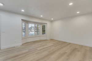 Empty room featuring light hardwood / wood-style floors and ornamental molding