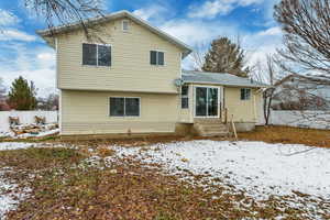 View of snow covered back of property