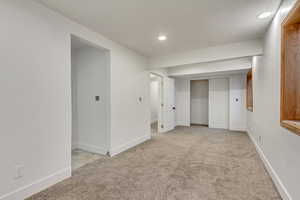 Basement featuring light colored carpet