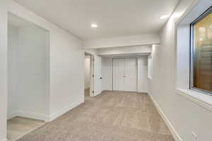 Hallway featuring light colored carpet