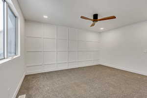 Empty room with ceiling fan and carpet floors