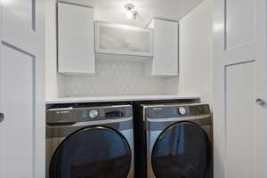 Laundry room with cabinets and washer and clothes dryer